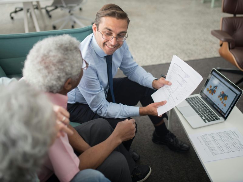 An Agent Showing Documents to an Elderly Man