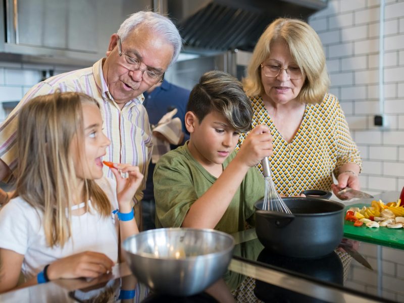 Elderly Woman Teaching Boy How to Cook